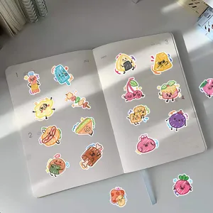 Close-up of vibrant cute graffiti food stickers decorated on an open notebook page