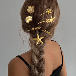 Nahaufnahme von eleganten goldenen Seestern- und Muschelhaarnadeln bei einer Flechtfrisur