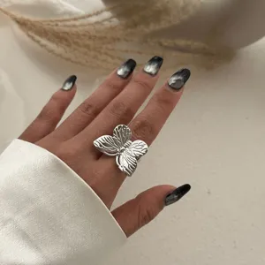 Exquisiter silberfarbener Schmetterlingsring mit detaillierten Flügeln an einer Hand