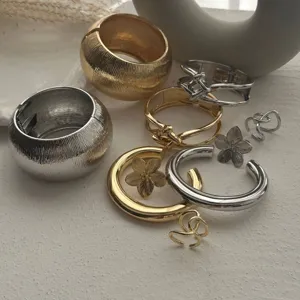 Makrodetail von metallischen gold- und silberfarbenen Armreifen und Armbändern