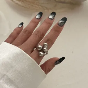 Detailaufnahme eines silbernen, klobigen Rings mit organischem Flüssigmetalldesign
