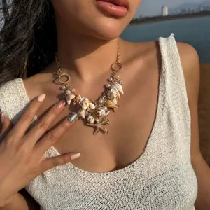 Detailed shot of Bohemian seashell necklace featuring starfish and pearl charms on a model