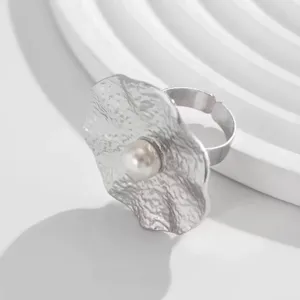 Detailansicht eines silbernen Rings mit Hammerschlag-Textur und einer zentralen Perle.