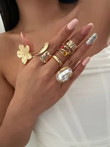 Detailaufnahme eines vintage Goldring-Sets mit Barockperle und floralem Blumendesign