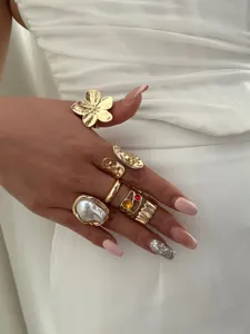 Detailansicht eines luxuriösen Vintage-Goldring-Sets mit Blumen- und Barockperlendesign.