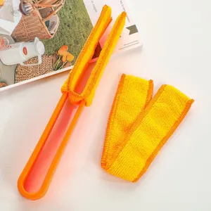 Detalle del cepillo limpiador de persianas con mango naranja y fundas de microfibra amarillas