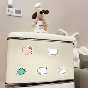 Dekorative bunte Sprechblasen-Aufkleber auf einem cremefarbenen Kühlschrank.