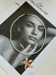 Elegant white pearl necklace featuring a pink enamel starfish pendant for summer style
