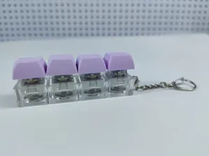 Detailed view of the 4-key mechanical keyboard switch keychain with pastel purple keycaps.