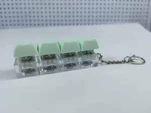 Close-up detail of the 4-key mechanical keyboard switch keychain with light-up green keycaps.