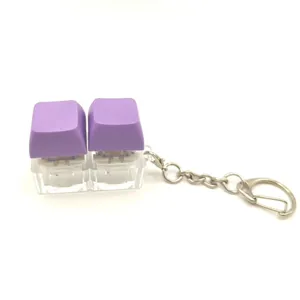 Double mechanical keyboard switch keychain with purple keycaps and light up stress relief design.