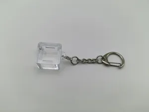 Detail of transparent mechanical keyboard switch tester base with silver metal keychain