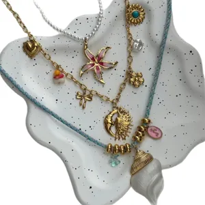 Vintage 14k gold layered necklace set with sun, moon, starfish, and conch charms.
