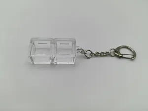Close-up detail of a transparent 2-slot mechanical keyboard switch tester keychain accessory