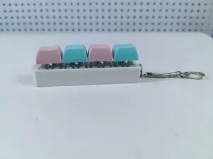 Side view detail of a 4-key mechanical keyboard switch fidget toy keychain in pink and blue