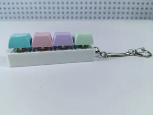 Close-up view of 4-key mechanical switch fidget keychain with pastel keycaps