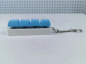 Detailed side view of a four-key mechanical switch tester fidget toy with blue keycaps