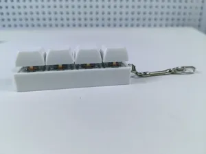 Detailed side view of a white 4-key mechanical keyboard switch fidget toy with keychain