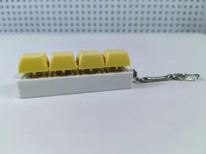 Detailed side view of a white mechanical keyboard switch keychain with four yellow keycaps.