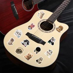 Decorative realistic cat stickers displayed on a wooden acoustic guitar body surface