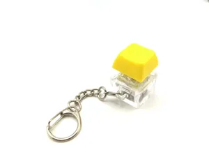 Close-up of mechanical keyboard switch keychain with yellow keycap for stress relief