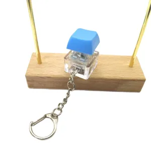 Minimalist blue mechanical keyboard switch stress relief keychain on wooden stand