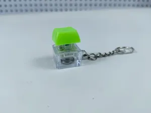Mechanical keyboard switch fidget toy keychain with transparent case and glowing light LED feature.