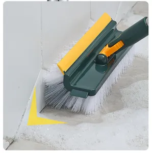 Close-up of a 5-in-1 cleaning brush scrubbing a bathroom floor-to-wall corner with foam