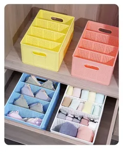 Vista dettagliata di scatole di stoccaggio in plastica scompartite per organizzare biancheria intima.