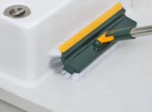 Detail view of 5-in-1 cleaning brush scrubbing sink edge and ceramic wall gaps