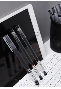 Primer plano de bolígrafos de gel negros colocados en un escritorio limpio con teclado.