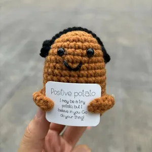 Handmade crochet potato doll detail, cute yarn plush toy with positive card holding view.