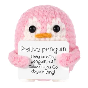 Vue détaillée d'un pingouin au crochet rose fait main tenant une carte de message positif