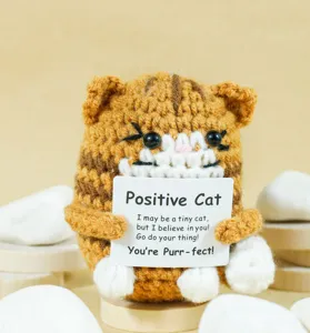 Handcrafted crochet cat toy detail view, cute positive animal design with encouraging sign card.