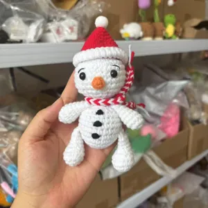 Handmade crochet snowman Christmas ornament with red Santa hat, cute knit holiday toy pendant.