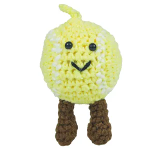Dettaglio di una bambola fatta a mano all'uncinetto con un sorriso giallo allegro.
