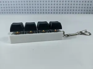 Close-up of a 4-key mechanical keyboard switch fidget toy keychain in black and white.