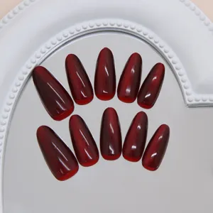 Gedetailleerd aanzicht van wijnrode kattenoog kunstnagels op een hartvormige spiegel.