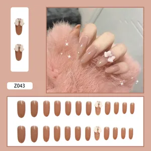 Detaillierte Ansicht von nudepinkfarbenen Glitzernägeln mit 3D-Schleife und Diamantakzent