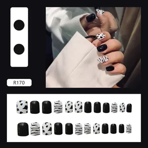 Detail of cow and zebra print press-on nails set with 24 pieces in black and white
