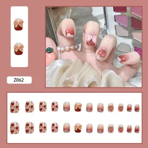 Umfassendes Set mit 24 Kunstnägeln mit süßen Schleifen-, Pfirsich- und Herzdesigns in Rosa.