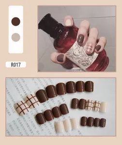 Macro view of 24pcs coffee brown and nude plaid patterned wearable press-on nail tips