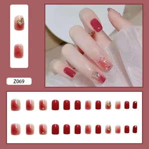 Elegante künstliche Nägel mit rot-rosa Farbverlauf, goldenen Schmetterlingen und Perlen
