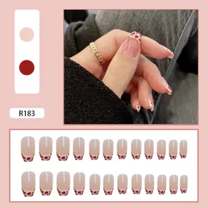 Set of 24 red heart cow print French tip press-on nails shown with model hand