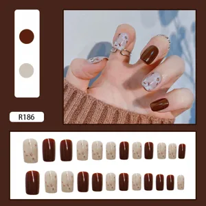 Brown and floral square-oval press-on nails detail showing full set and model wear