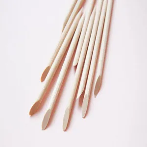 Close-up detail of high-quality double-ended orange wood sticks for professional nail cleaning