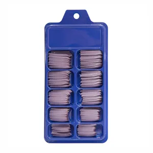Vista completa de puntas de uñas postizas moradas en diez ranuras de una caja azul