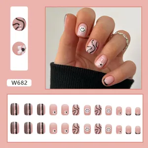 Set unghie finte corte rosa con faccine, vortici neri e motivi floreali bianchi