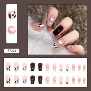 Vue détaillée de 30 faux ongles autocollants avec motif vache et cœurs en 3D.