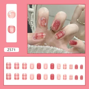 Vue détaillée des faux ongles roses à motifs de cœur avec une présentation du kit